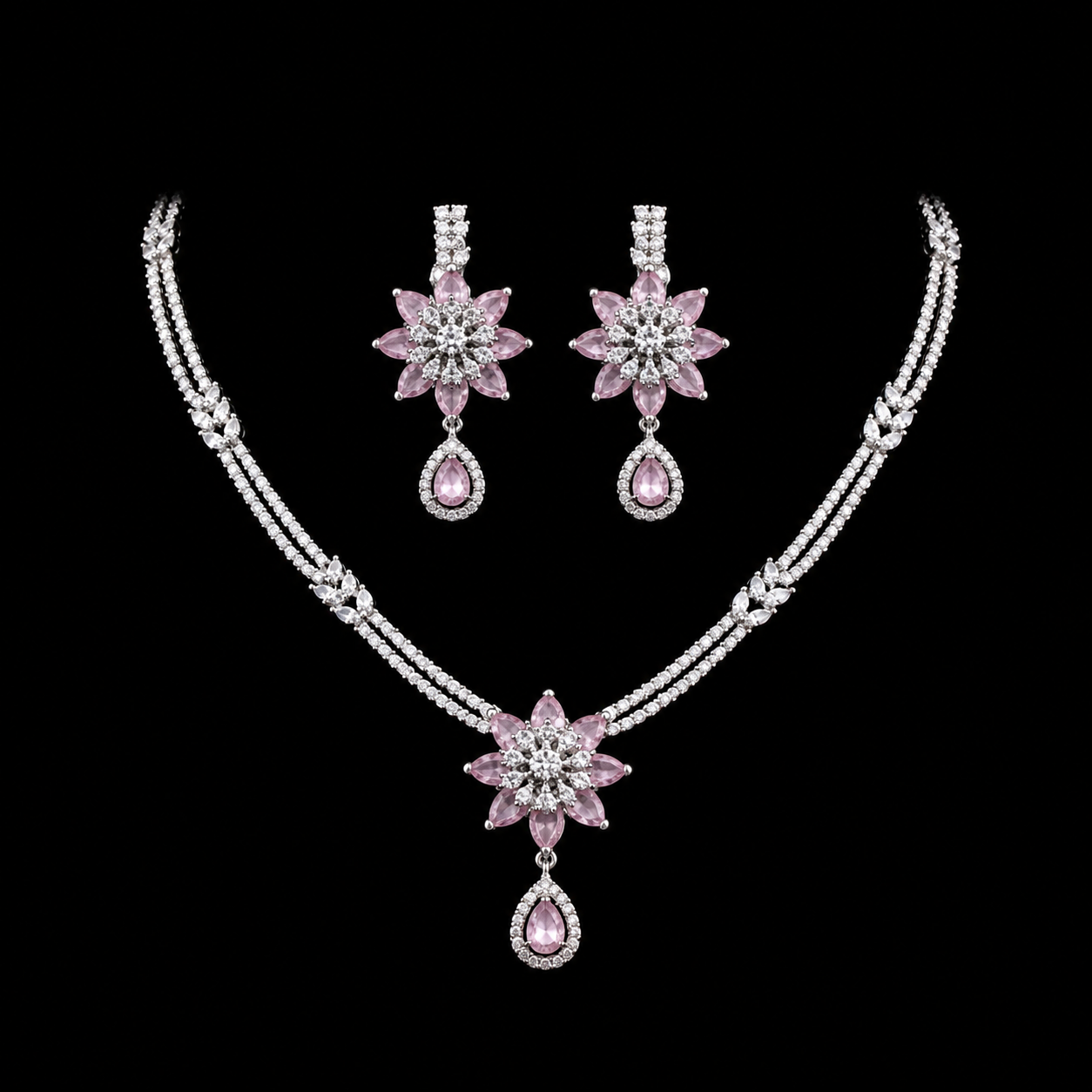 A graceful necklace and earring set featuring a floral-inspired design with sparkling pink and clear stones.