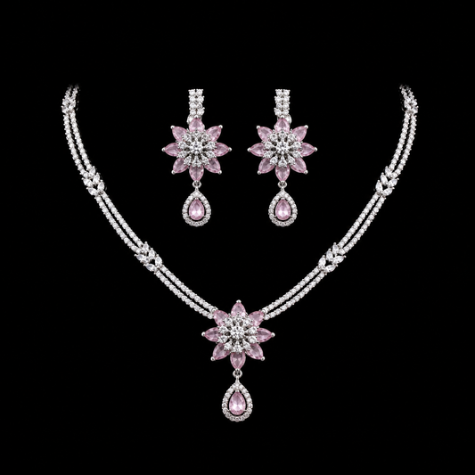 A graceful necklace and earring set featuring a floral-inspired design with sparkling pink and clear stones.